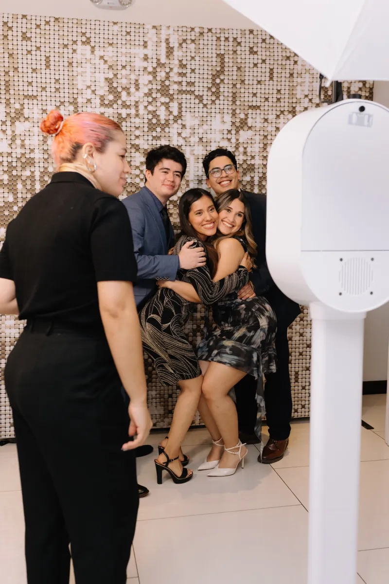 Integrante del equipo InstaBloom acomoda a cuatro invitados abrazados frente a la cabina